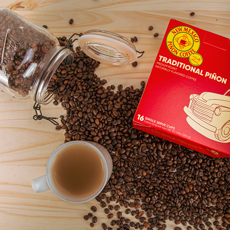 Branded coffee retail box displayed with scattered coffee beans and a mug