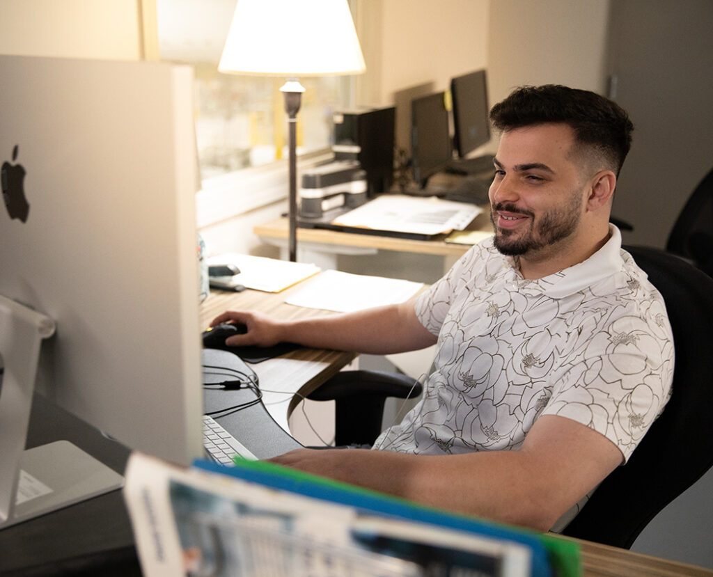 Team member reviewing artwork at a desktop computer workstation