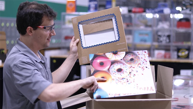 SCT employee packaging a windowed bakery box and a printed stock bakery box.